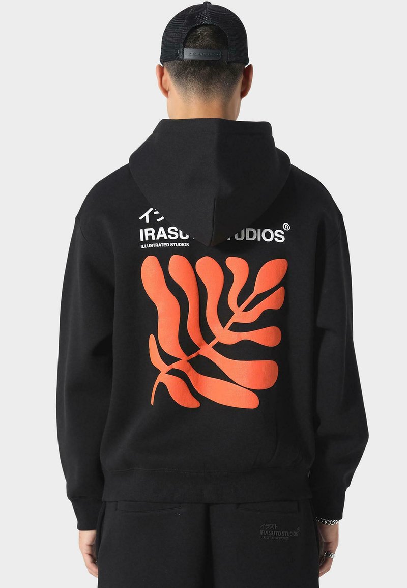 Černá mikina s kapucí z bavlny s velkým oranžovým listovým vzorem na zádech, s textem "IRASUTO STUDIOS" v bílé barvě nad designem.
