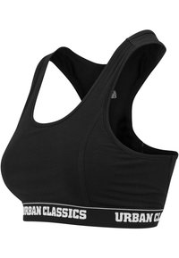 Crni sportski grudnjak od rastezljivog materijala, s dizajnom na leđa i širokom elastičnom trakom na kojoj piše "URBAN CLASSICS" u bijelom.}}