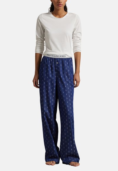 Vit långärmad skjorta och marinblå pyjamasbyxor med ett subtilt mönster av hästar och resårmidja med "POLO RALPH LAUREN"-logotyp.