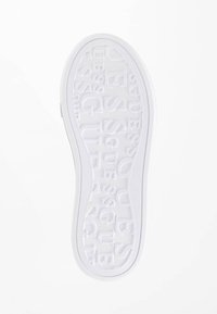 Semelle de chaussure blanche en caoutchouc avec un motif de logo embossé, des bords texturés et une finition lisse.