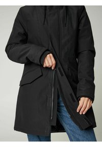 Juodas parka paltas, pagamintas iš lygaus audinio, su priekiniais užtrauktukais, Velcro užtrauktukais ir šoninėmis kišenėmis. Dizainas turi laisvą siluetą.