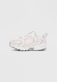 Λευκό και απαλό ροζ αθλητικό παπούτσι με πάνελ από δίχτυ και γκρι σόλα, απεικονίζεται από το πλάι σε απλό λευκό φόντο.