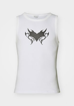 Biela bezrukávová blúzka vyrobená z bavlny s čiernym kmeňovým srdcovým dizajnom v strede. Má okrúhly výstrih a rebrovanú textúru.