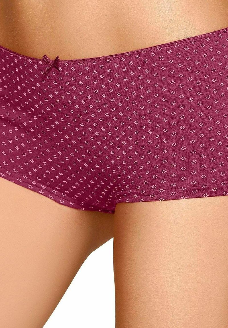 Burgundské nohavičky vyrobené z jemného materiálu, s decentným kvetinovým vzorom a mašľou na páse. Hladký povrch, stredne vysoký strih.