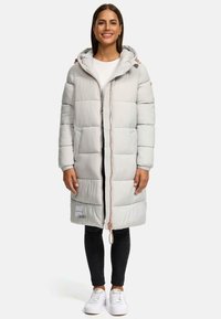 Light gray puffer coat with a hood, featuring horizontal quilted texture, zipper closure, and pockets. Worn with black pants and white sneakers.