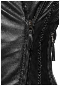 Schwarze Lederjacke mit glatter Textur, auffälligen Reißverschlüssen, geflochtenen Akzenten und Fransenverzierungen an der Seite.