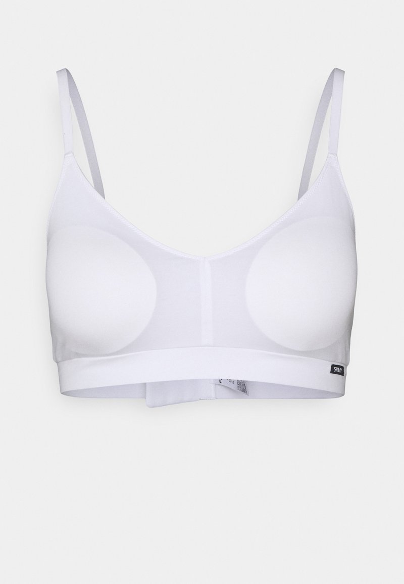 Bralette branca feita de tecido elástico, com dois copos almofadados circulares, alças finas ajustáveis e uma faixa larga na parte inferior.
