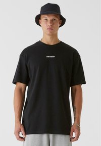 Black cotton t-shirt with short sleeves and a crew neck, featuring a white "LOST YOUTH" logo centered on the chest. Simple design.
