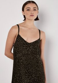 Sukienka satynowa z głębokim dekoltem w serek, cienkimi ramiączkami i wzorem leopardzim w ciemnozielonym kolorze, o zwiewnej sylwetce i miękkiej fakturze.