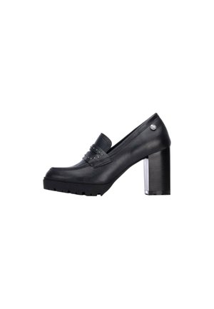 Mocasín negro de piel con tacón alto, detalle de tira con tachuelas y tacón grueso en bloque sobre fondo blanco.
