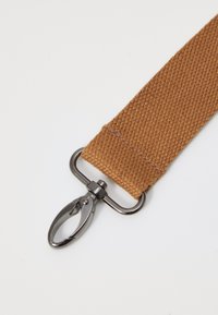 Correia de tecido castanho com uma superfície texturada, apresentando um fecho de metal prateado para ligação. Fina, durável, com bordas cosidas.