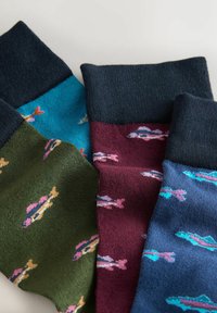 Vier Paar Socken mit Fischmustern in lebhaften Farben: Türkis, Grün, Kastanienbraun und Marineblau, mit kontrastierenden dunklen gerippten Bündchen.