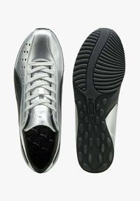 Sneakers sintetiche argento con suola in gomma nera, design traforato e lacci bianchi. Logo Puma sulla linguetta e sulla suola.