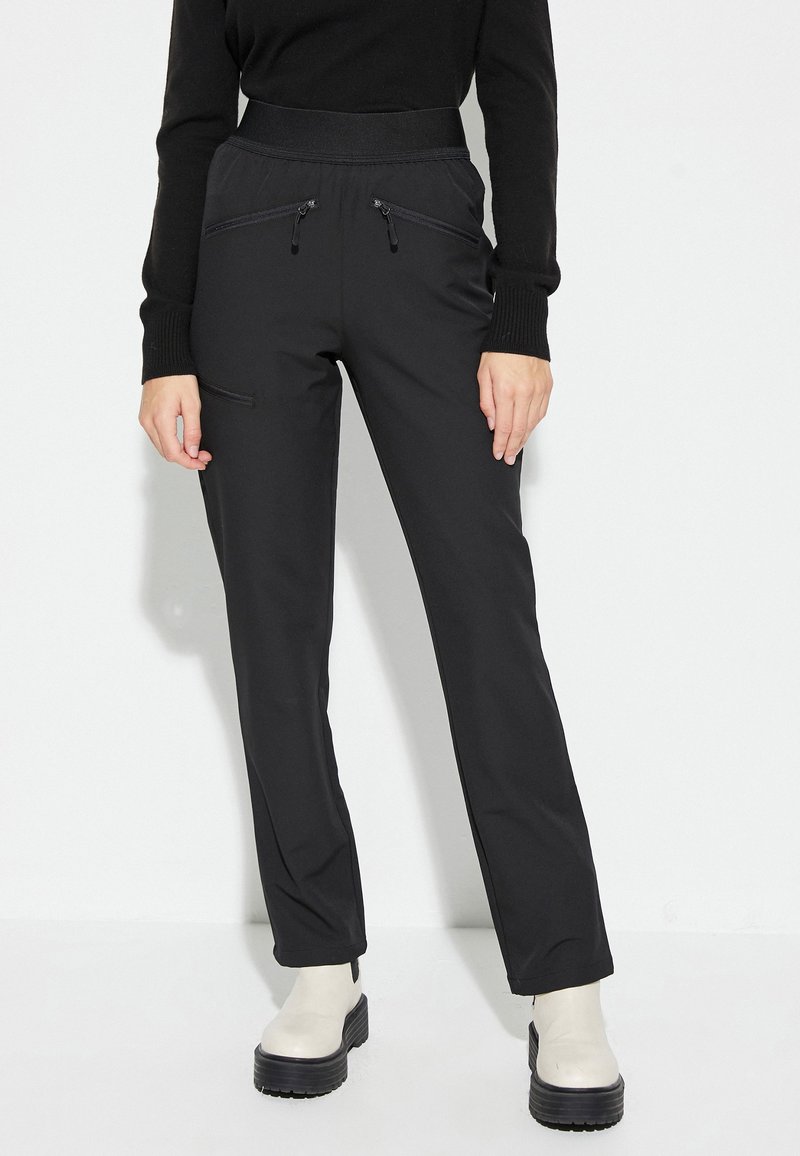 Pantalones negros con una cinturilla alta, que cuentan con dos bolsillos con cremallera. Están hechos de una tela suave y elástica; tienen un corte de pierna recta.