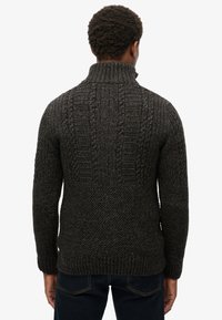 Dunkelgrauer Strickpullover mit hohem Kragen, der ein strukturiertes Muster und gerippte Bündchen aufweist, von hinten gezeigt. Lässige Passform.
