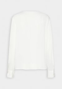 Weiße Bluse mit langen Ärmeln aus glattem Stoff. Hat ein schlichtes Design, seitliche Schlitze und Knopfakzente an den Manschetten. Rückansicht gezeigt.