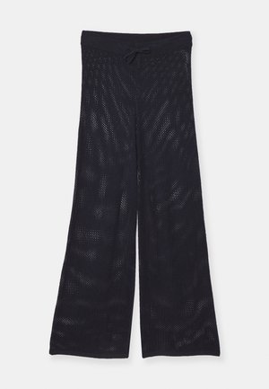 Schwarze, locker sitzende, weite Hosen aus einem atmungsaktiven Mesh-Stoff. Mit einem elastischen Bund und einem Kordelzug zur Anpassung.