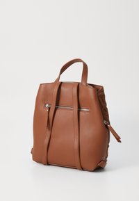 Zaino in pelle marrone con forma strutturata, manici superiori, spallacci regolabili e una tasca con zip frontale. Texture liscia e design minimalista.