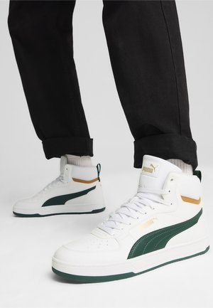 Zapatillas altas de cuero blanco con detalles en verde y branding en dorado. Presentan un acabado texturizado, diseño con cordones y cuello acolchado.