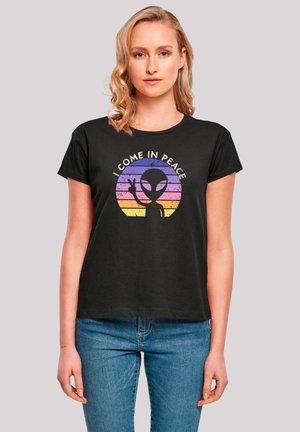 Schwarzes Baumwoll-T-Shirt mit einer Grafik einer Alien-Silhouette vor einem Verlaufskreis aus pinken, lila und gelben Streifen mit Text.