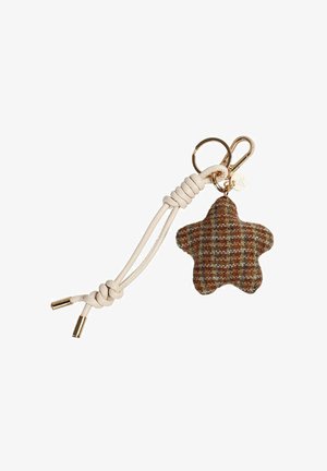 Llavero en forma de estrella hecho de tela de cuadros marrón y verde con un cordón de color crema. Presenta herrajes en tono dorado y un pequeño charm.