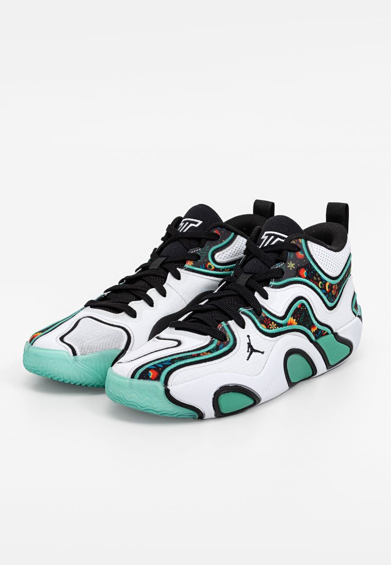 Baskets montantes blanches et noires avec des semelles cyan et des motifs floraux et d'étoiles colorés sur les côtés, dotées de lacets noirs et d'accents de logo.