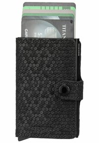 Black wallet with a hexagonal textured pattern, holding several cards. Features a button closure and a sleek, minimalist design.
