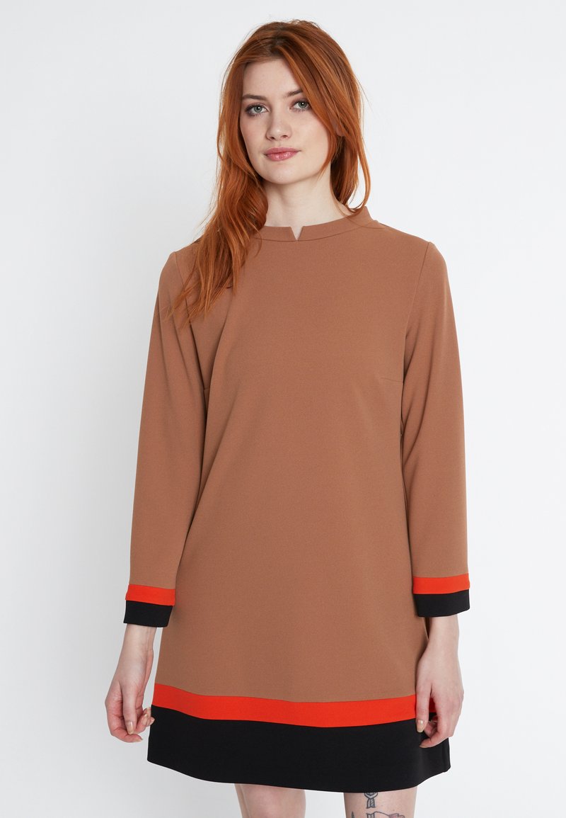 Braunes, langärmliges Kleid mit rundem Ausschnitt, das rote und schwarze horizontale Akzente an den Ärmeln und am Saum aufweist. Glatte Stofftextur.