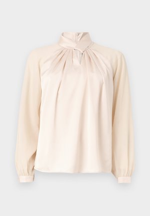 Kreminės spalvos ilgomis rankovėmis palaidinė su aukštu apykakliu, raukšlėtu priekiniu bei raktelio formos iškirptės detale, nufotografuota ant vienspalvio fono.