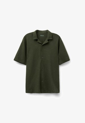 Tmavě zelená krátký rukáv pletená košile s límcem ve stylu kempu a předními knoflíky, zobrazena naležato na bílém pozadí.
