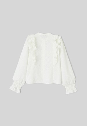 Blouse blanche à manches longues avec des accents de volants le long des épaules, en tissu œillet texturé ; poignets élastiqués et fermeture à boutons au dos.