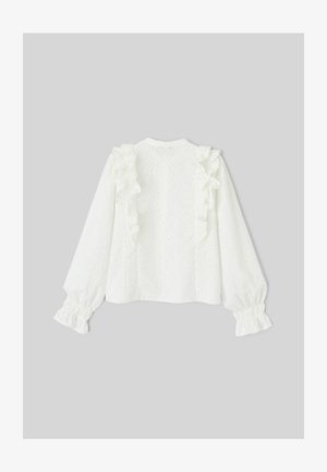 Blouse blanche à manches longues avec des accents de volants le long des épaules, en tissu œillet texturé ; poignets élastiqués et fermeture à boutons au dos.