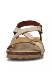 Sandali in pelle color cammello chiaro e crema con cinturini incrociati, suola in sughero e suola in gomma resistente. Dotati di cinturino regolabile con fibbia.