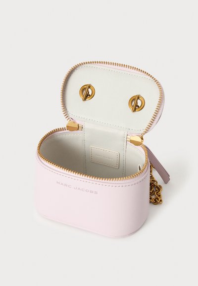 Μικρή ανοιχτό ροζ δερμάτινη τσάντα Marc Jacobs με χρυσό φερμουάρ, αλυσίδα λουρί και ανοιχτή κορυφή που δείχνει απαλή εσωτερική επένδυση.