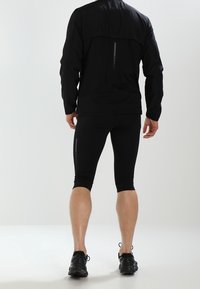 Schwarze Sportjacke und enganliegende Shorts, mit reflektierenden Akzenten, glatter Textur und knielangem Design. Eignet sich für Aktivitäten im Freien.