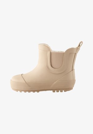Bottine beige imperméable à la cheville avec semelle texturée, panneau latéral élastique, languette de traction et doublure intérieure en polaire.