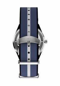 Timex pulksteņi ar tumši zilu neilona siksnu, kas decorēta ar baltu strīpu, sudraba aparatūru un apaļu sudraba toņa korpusu.