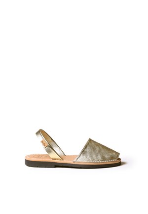 metallic gold slingback sandal with a flat black sole and a simple triangular design, featuring a smooth texture and stitched detailing.