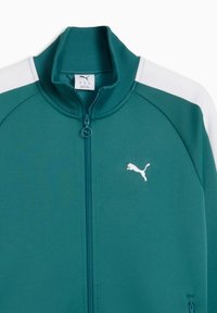 Τζάκετ με φερμουάρ σε τιρκουάζ απόχρωση, με ριμπ κολάρο, λευκές λεπτομέρειες στους ώ μους και μικρό λευκό λογότυπο της Puma στο στήθος. Υφή υφάσματος με πλαϊνές τσέπες.