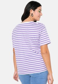 Fioletowo-biały w paski t-shirt z krótkim rękawem o luźnym kroju, z okrągłym dekoltem i miękką fakturą materiału.