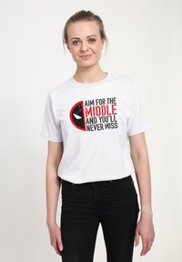 Hvid bomuld t-shirt med sort og rød grafisk tekst, der står "Sigte efter midten, og du vil aldrig ramme ved siden af", med et cirkulært maskerede design.