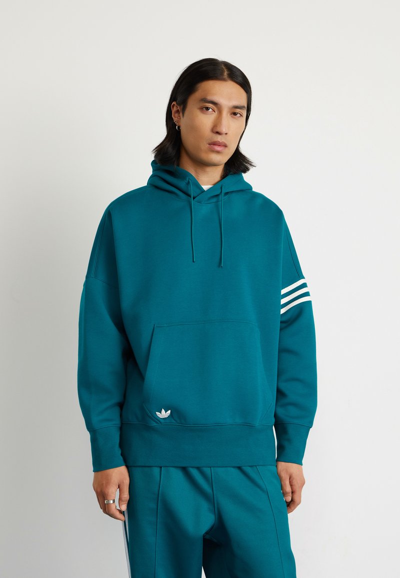 Felpa di colore teal con tasca frontale, cappuccio con cordino e tre strisce bianche sulla manica destra. Presenta un piccolo logo bianco all'orlo.