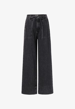 High-waist black wide-leg jeans with large front patch pockets and a thin tied belt at the waist.