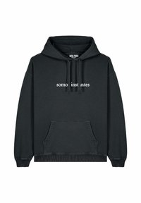 Hoodie nero in cotone, con tasca frontale, polsini e orlo a coste, e il testo "somos instantes" in bianco sul petto.