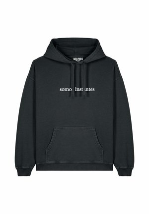 Schwarzer Hoodie aus Baumwolle, mit einer Fronttasche, gerippten Bündchen und Saum sowie dem Text "somos instantes" in Weiß auf der Brust.
