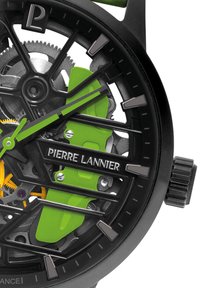 Reloj esqueleto negro de Pierre Lannier con acentos verdes, mecanismos visibles y esfera negra. Presenta marcadores de hora audaces y una corona texturizada.