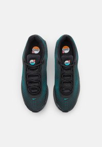 Black sneakers with a mesh design featuring turquoise accents and dot patterns. Rounded toe, lace-up front, and visible cushioning logo.