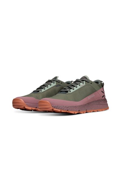 Une paire de chaussures de sport vertes et roses avec des semelles texturées et un système de laçage, vue à un léger angle sur un fond blanc uni.