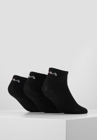 Schwarze Knöchelsocken mit elastischen Bündchen, mit dem Fila-Logo in Weiß und Rot. Weiches Material, glatte Textur, verpackt in einem Set von drei.