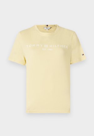 Sárga pamut póló rövid ujjakkal és kerek nyakkal. A pólón fehér betűkkel a következő felirat található: "TOMMY HILFIGER EST. 1985". Kicsi logó a ruhadarab ujján.